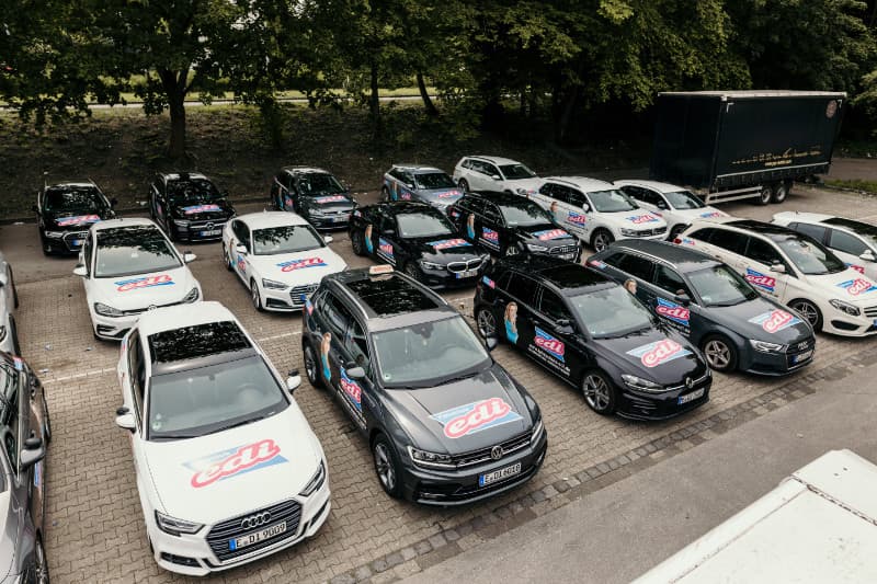 Flotte von weißen und schwarzen Schulungsfahrzeugen